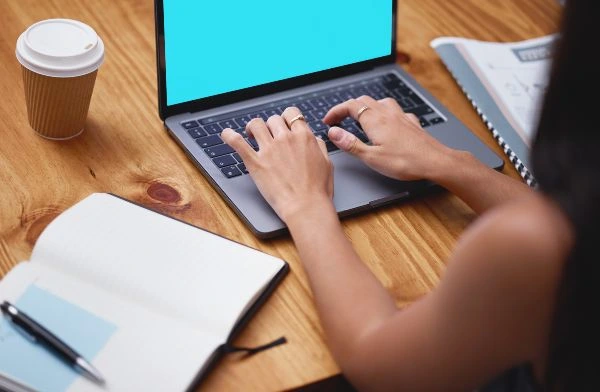 SEO Monterrey; imagen de una mujer escribiendo en su computadora portátil para realizar una serie de estrategias de posicionamiento efectivo para un negocio online.
