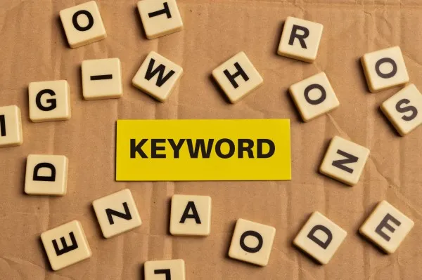 Disposición de letras de scrabble alrededor de una etiqueta amarilla simbolizando la importancia de las keywords short tail en marketing digital.